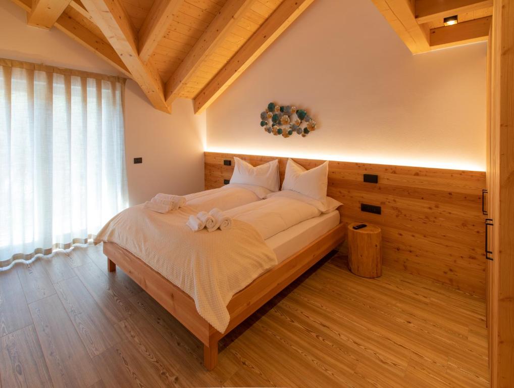 um quarto com uma cama grande num quarto em Brenta Rosso - Charme Apartments em Fai della Paganella