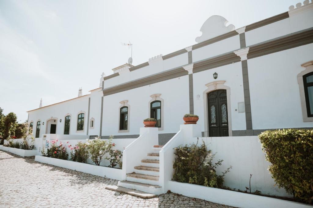 a row of white buildings with stairs and flowers at Cerca Velha - Country House in Albufeira