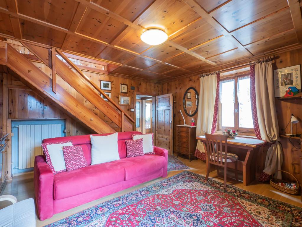 a living room with a pink couch and a desk at I Host Apartment - Centrale 16 in Piatta