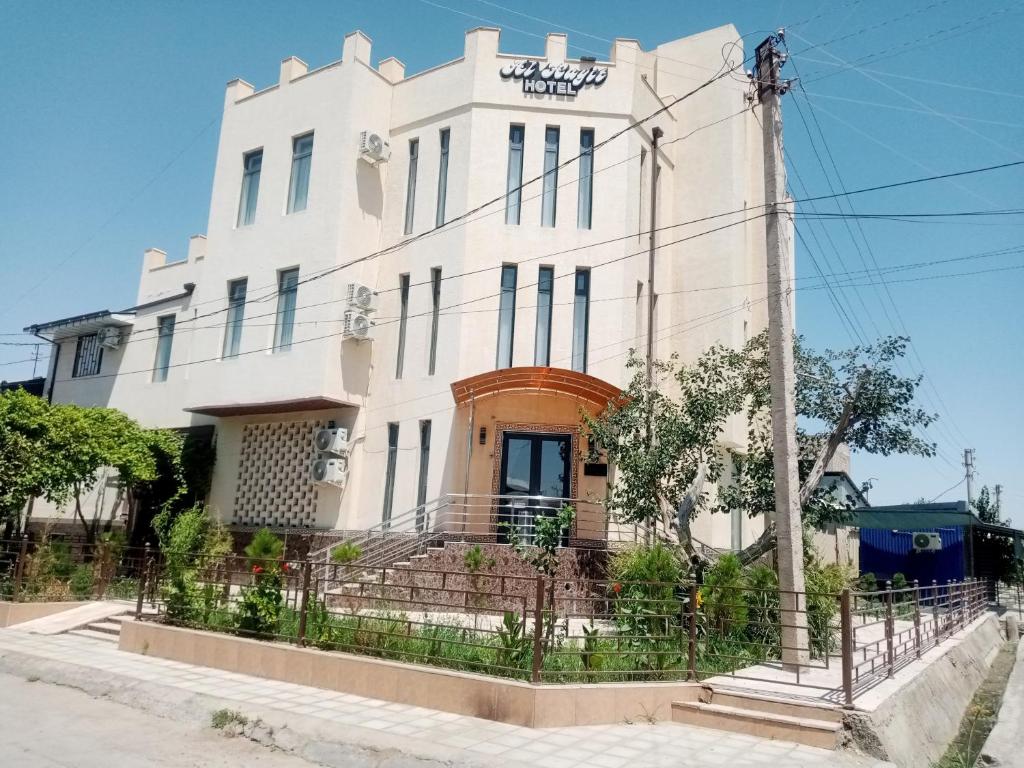 un edificio blanco con un cartel. en Hotel Al Hayit Teracce en Bukhara