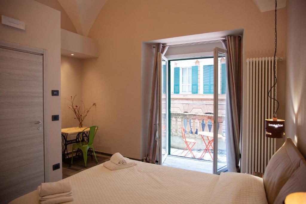 een slaapkamer met een bed en een deur naar een balkon bij Le Caravelle Affittacamere in Genua