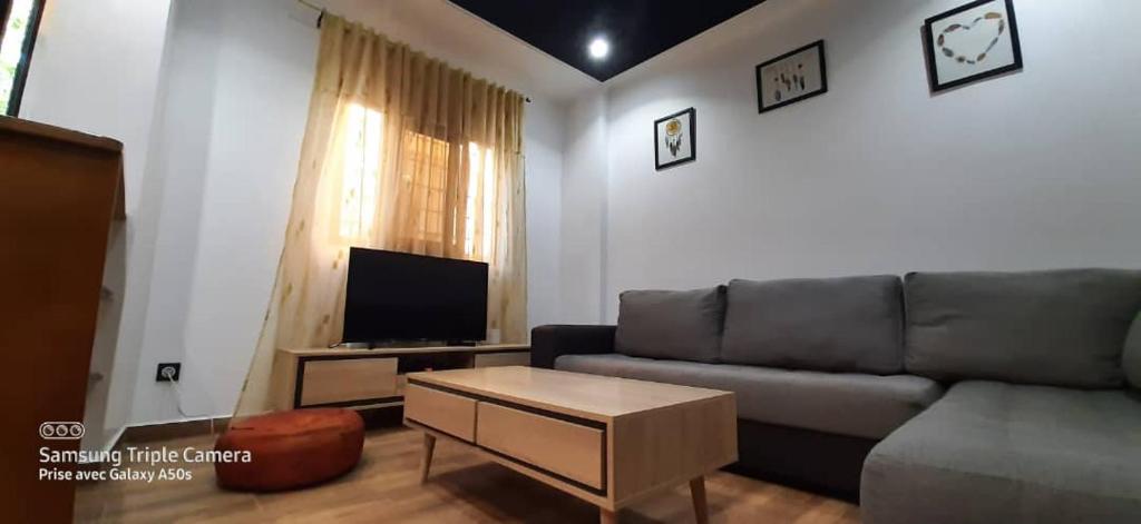 een woonkamer met een bank en een tv bij Alger Draria f2 in Alger