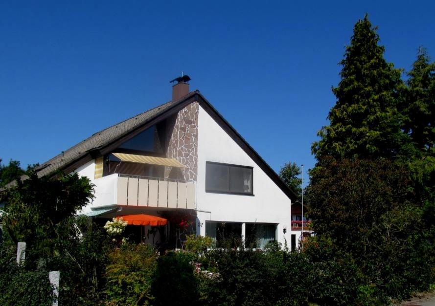 een wit huis met een boom ervoor bij Ferienwohnung "Auszeit" - Familie Moll-Staudt, Langenargen am Bodensee in Langenargen