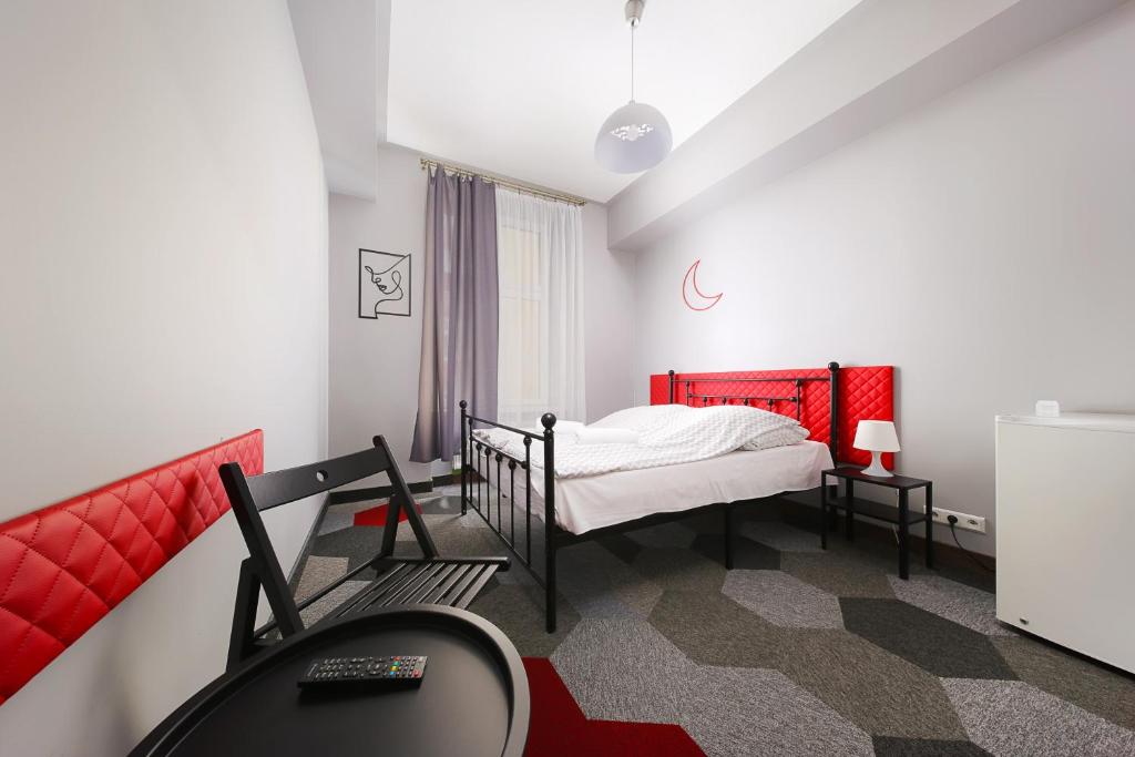 niewielka sypialnia z łóżkiem i biurkiem w obiekcie Moon Hostel Kraków w Krakowie