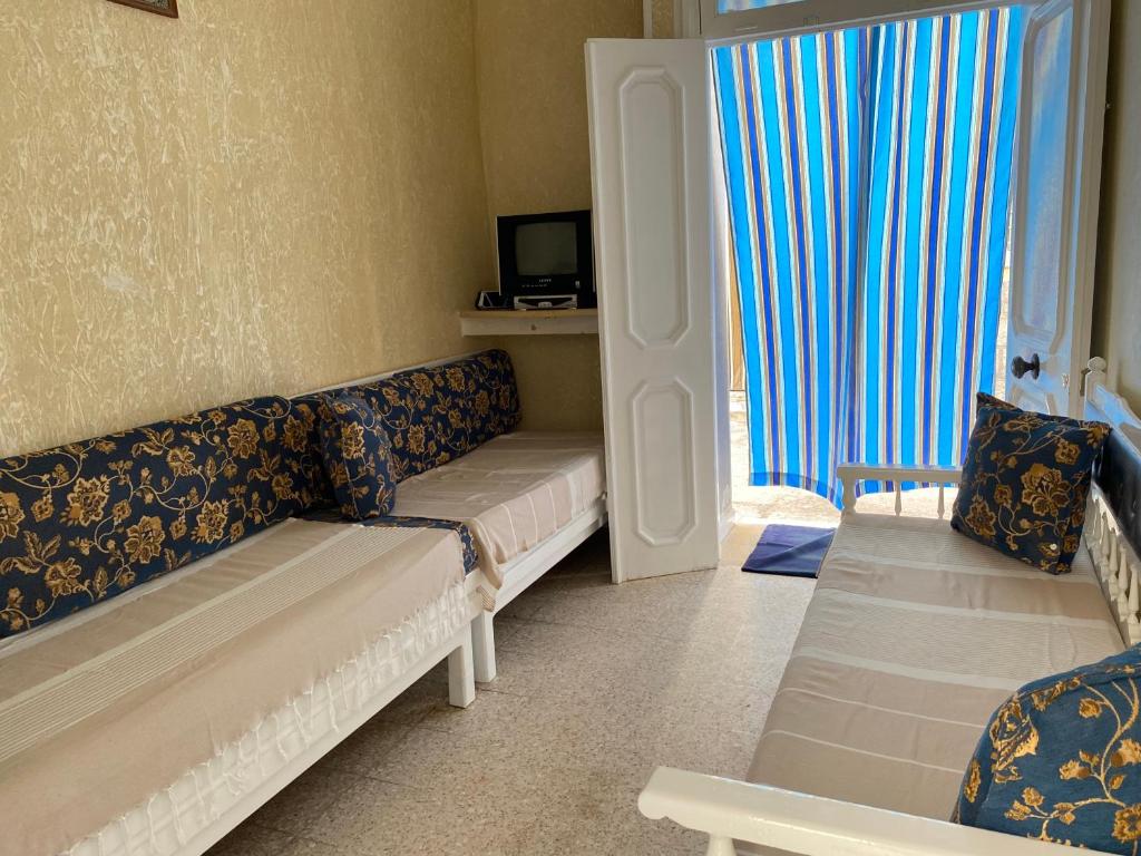 a living room with two couches and a television at Le bien être in Kelibia