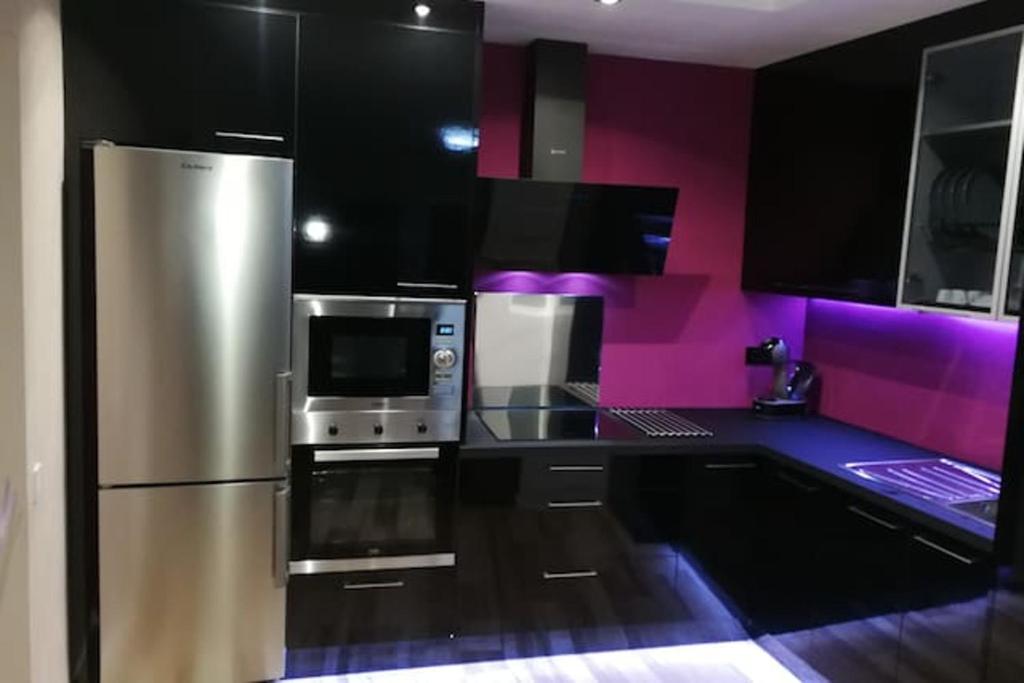 cocina con nevera de acero inoxidable y paredes púrpuras en 3 bedrooms apartement with wifi at Las Palmas de Gran Canaria, en Las Palmas de Gran Canaria