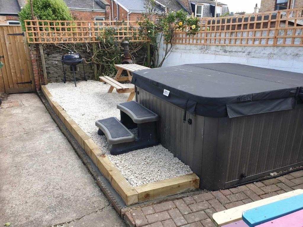 a black dumpster with a bench and a table at Belmont Villa in Ilfracombe