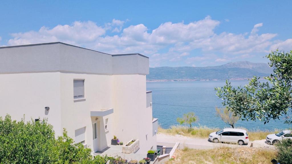 une maison blanche avec vue sur l'eau dans l'établissement Apartment Rovci 2, à Slatine