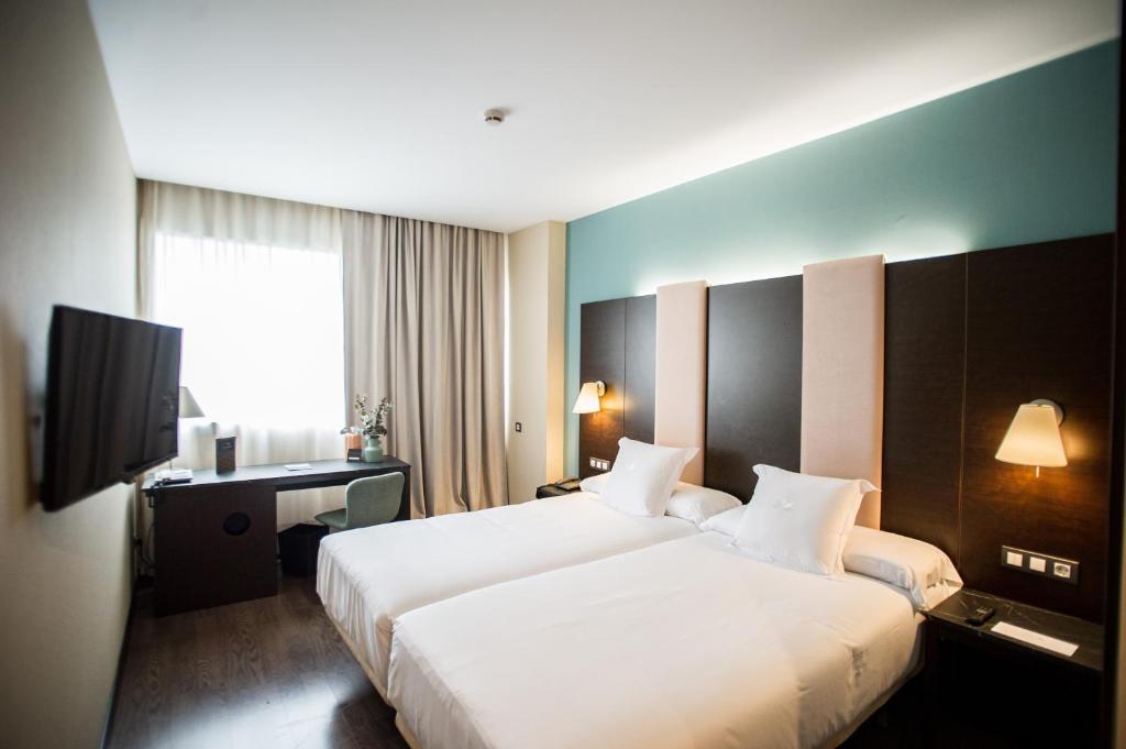 Postelja oz. postelje v sobi nastanitve AZZ Pamplona Norte Hotel