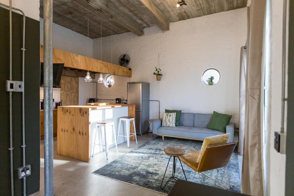- un salon et une cuisine avec un canapé bleu dans une chambre dans l'établissement GreenHouse APARTMENT, à Mount Road