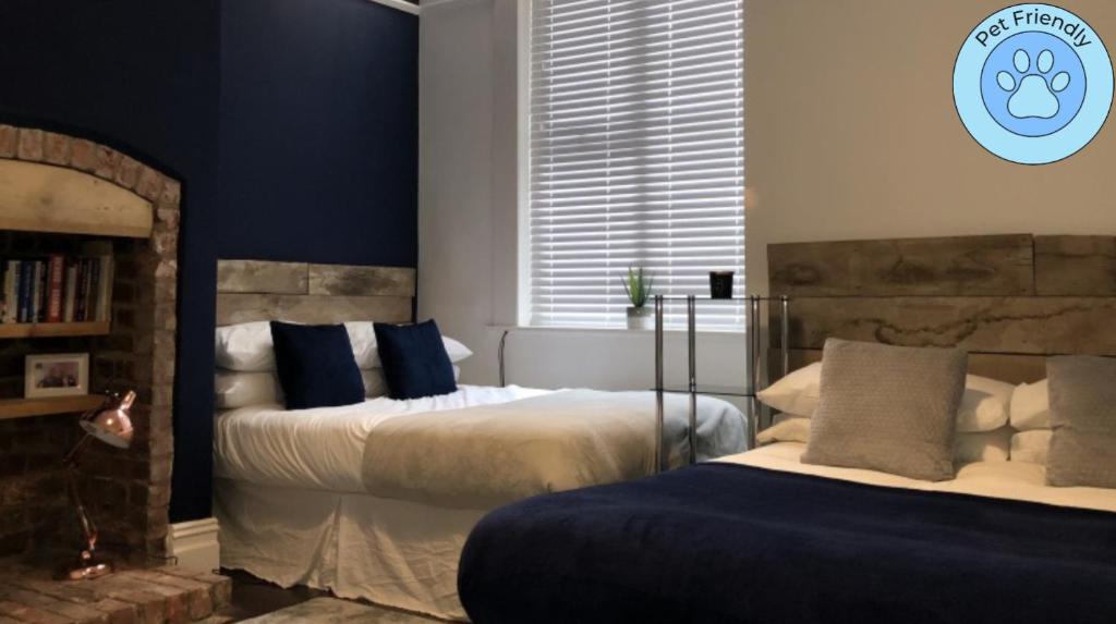 a bedroom with two beds with blue walls at Sapphire House Sasco Apartments in Blackpool