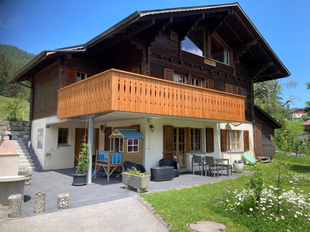 a large wooden house with a balcony on top at Chalet Hagenbächli in Schwarzsee