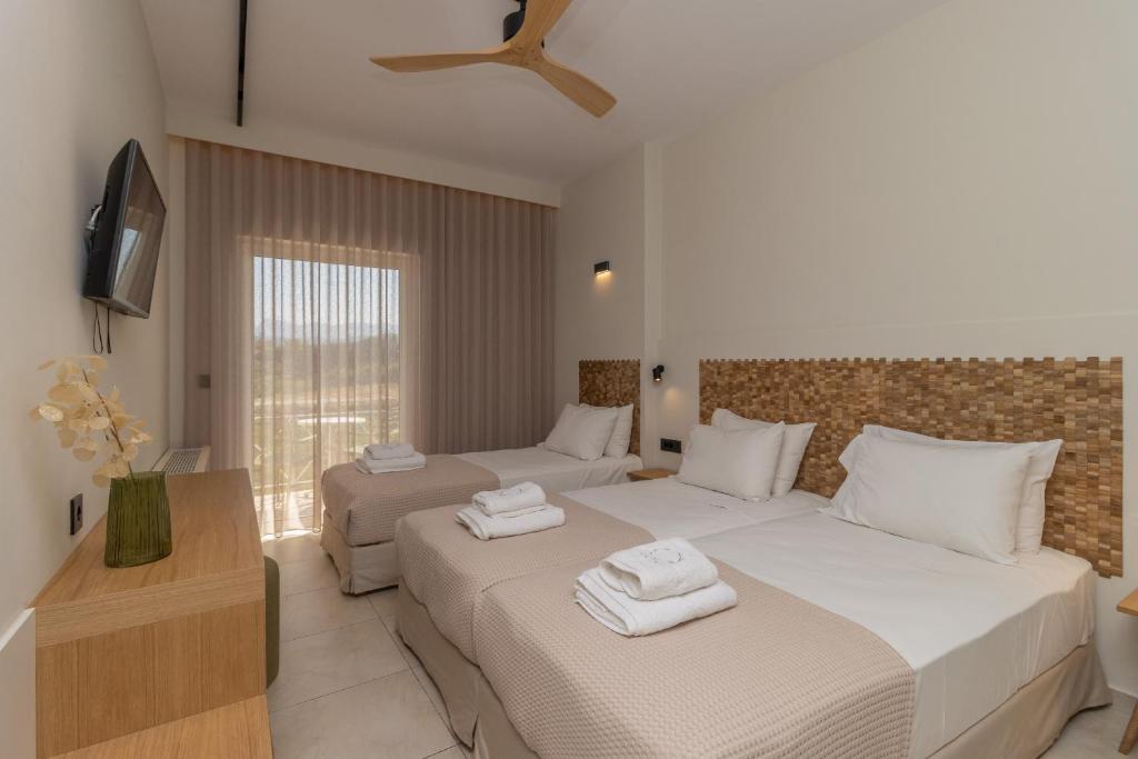 een hotelkamer met 2 bedden en een televisie bij Artina in Marathopolis