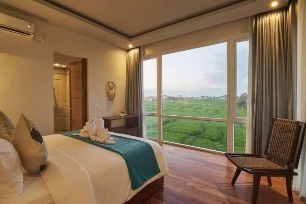 ein Schlafzimmer mit einem großen Bett und einem großen Fenster in der Unterkunft Araya Luxe Villa in Munggu