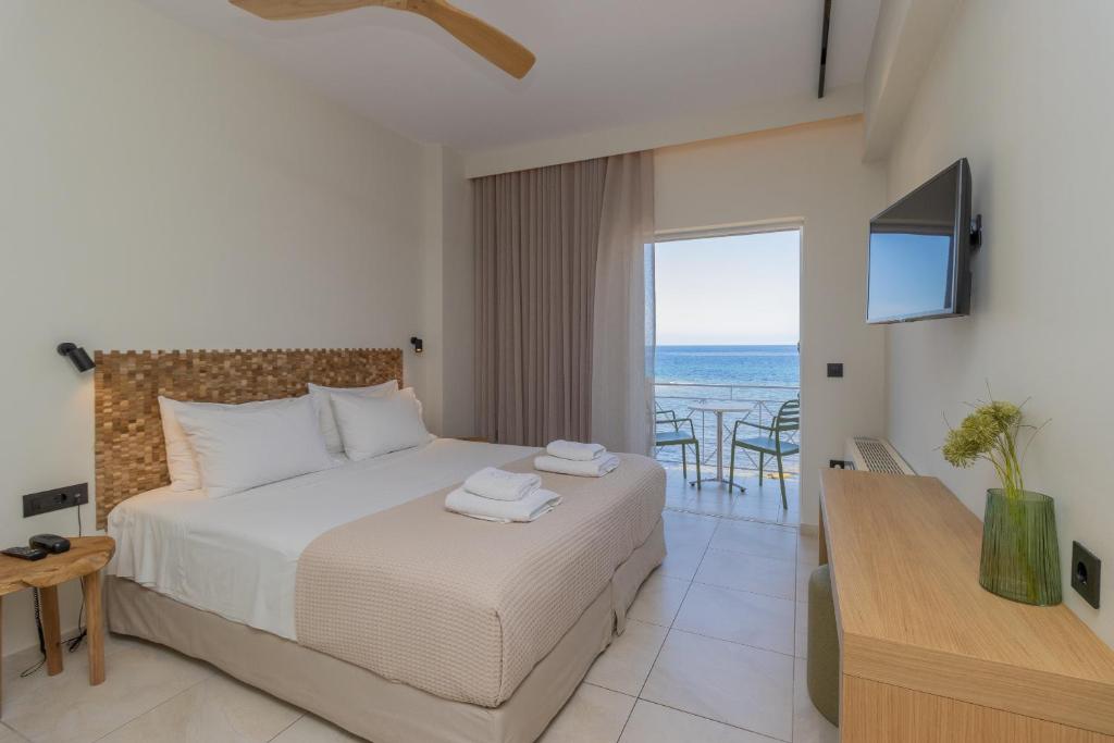 a bedroom with a bed and a view of the ocean at Artina in Marathopoli