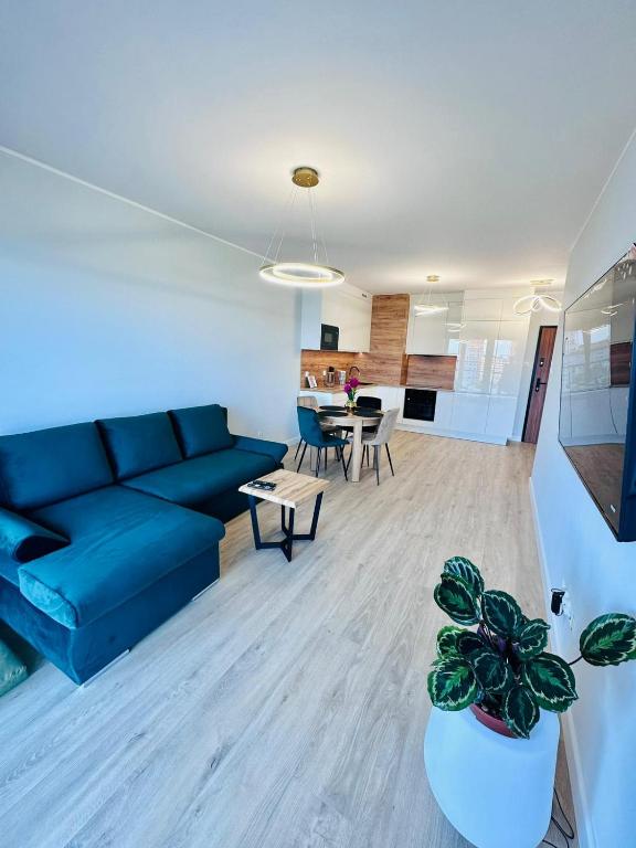 a living room with a blue couch and a table at Apartament Nadmorski in Gdańsk