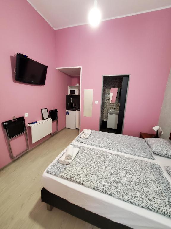 a bedroom with a large bed and a pink wall at Klauzal19 Rooms in Budapest