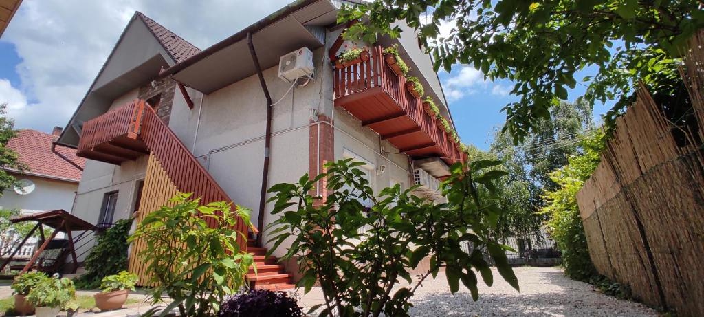 a house with a staircase and a fence at Timbi Vendégház in Vonyarcvashegy