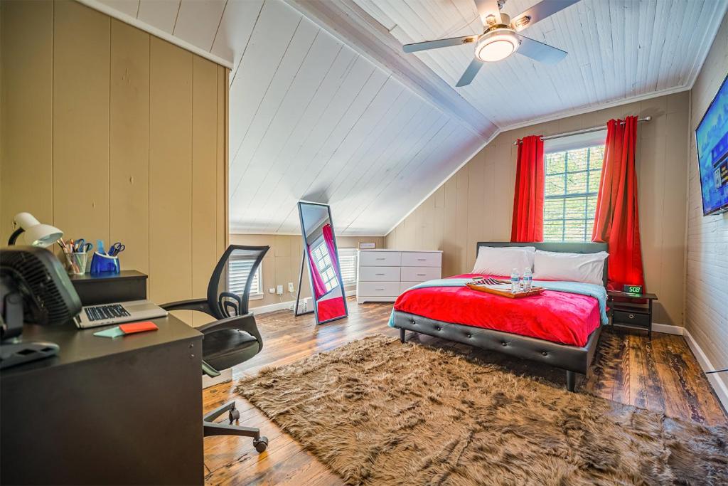 a bedroom with a red bed and a desk with a computer at Daydream by The Atlanta Beltline Trail in Cabbagetown in Atlanta