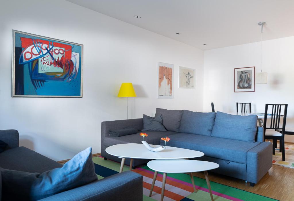 uma sala de estar com um sofá azul e uma mesa em Spacious, quiet 4 room flat em Salzburgo