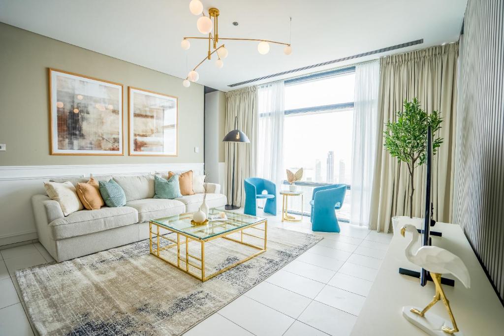 un soggiorno con divano e tavolo di Nasma Luxury Stays - Exquisite Hideaway With Awe-ins Burj Khalifa Views a Dubai