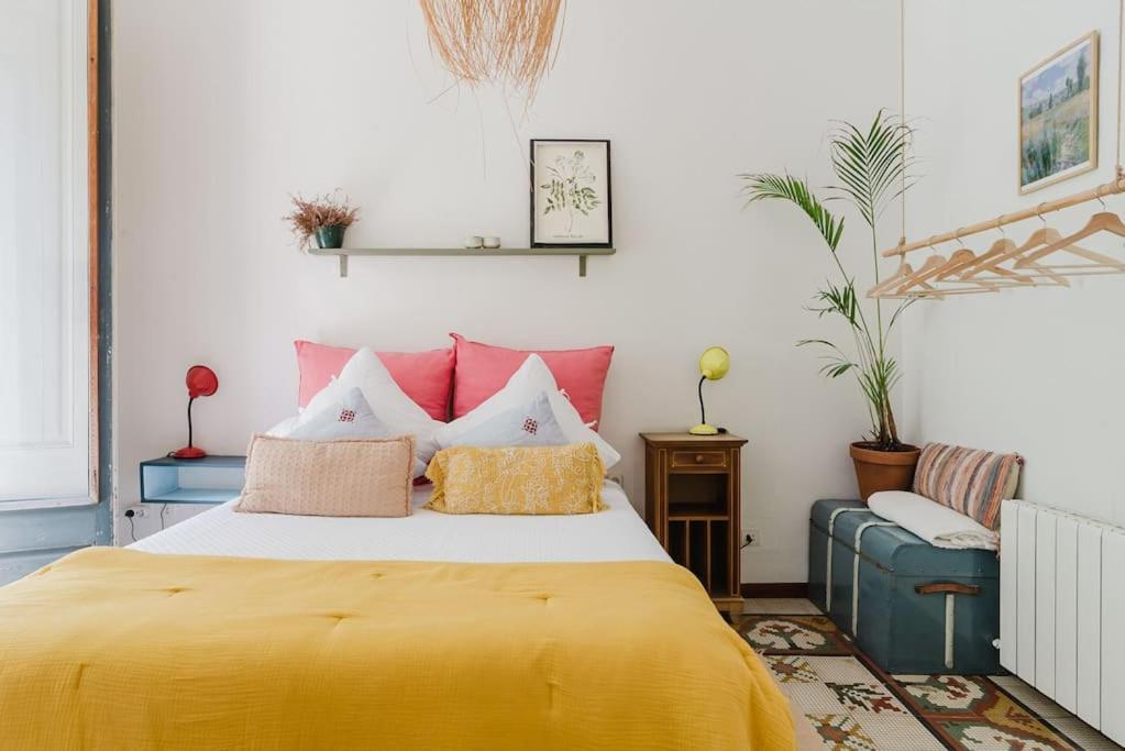 a bedroom with a large yellow bed with red pillows at Habitación en La Rambla in Girona