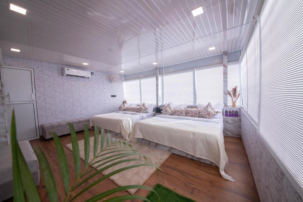 a room with two beds and a large window at Perfectstayz Homes I Luxury Penthouse in Haridwār