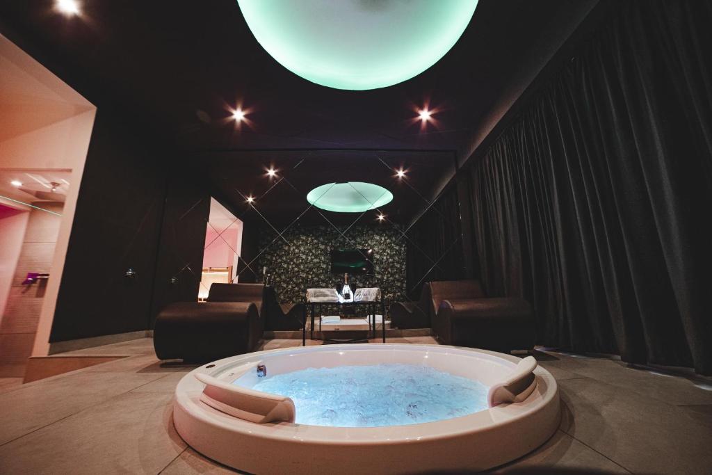 a large tub in a room with a table and chairs at Capri Spa Hotel in Casoria