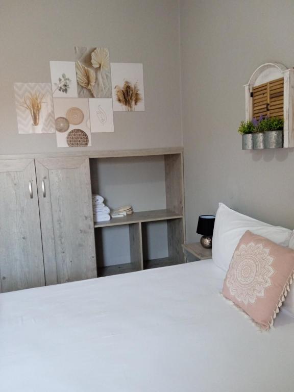 a bedroom with a large white bed and a shelf at Almira - rooms to let in Nea Roda