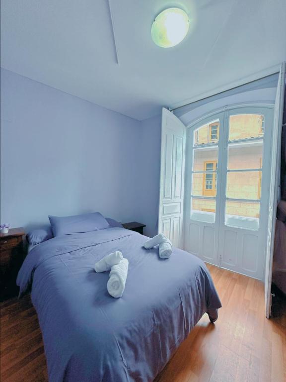 a blue bedroom with a bed with towels on it at Habitacion privado con baño privado en La Maresía in Cudillero