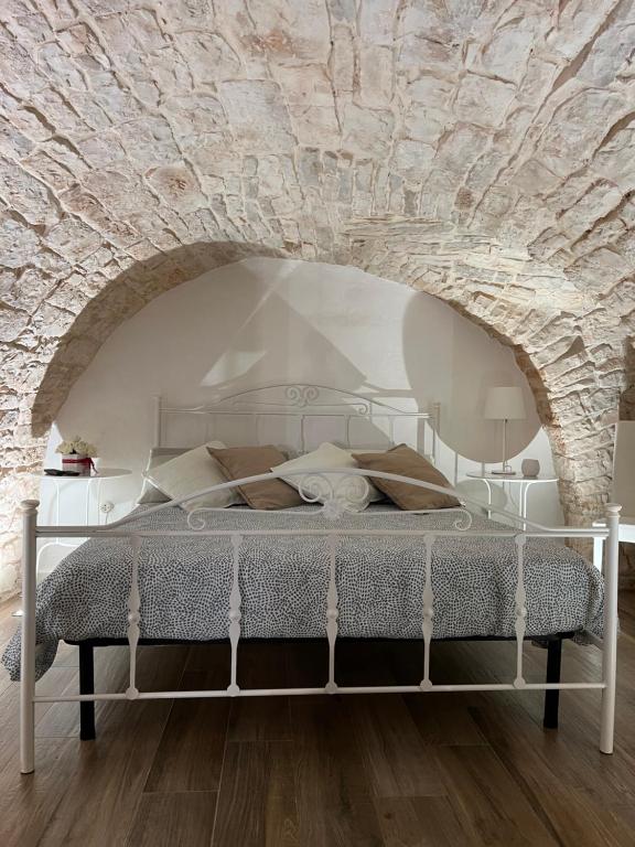 Cama en habitación con pared de piedra en Dimora martina, en Loseto
