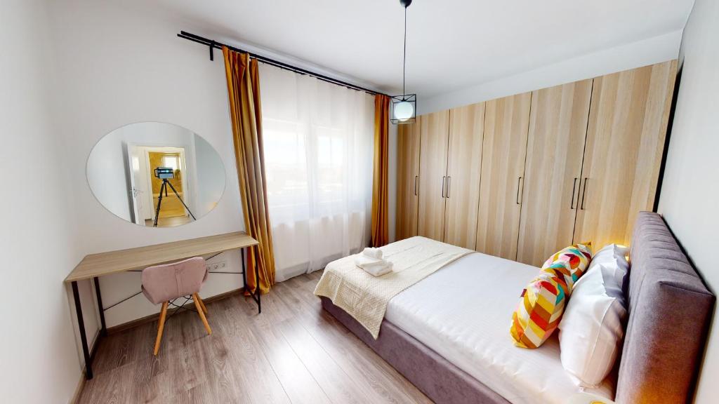 een slaapkamer met een bed en een spiegel bij Deventer Residence VRT in Sibiu