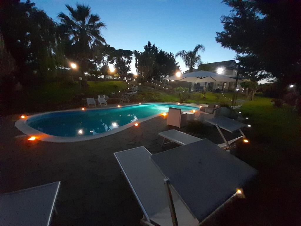 een uitzicht op een zwembad in de nacht bij Luxury bnb Le Rocce in Villasmundo