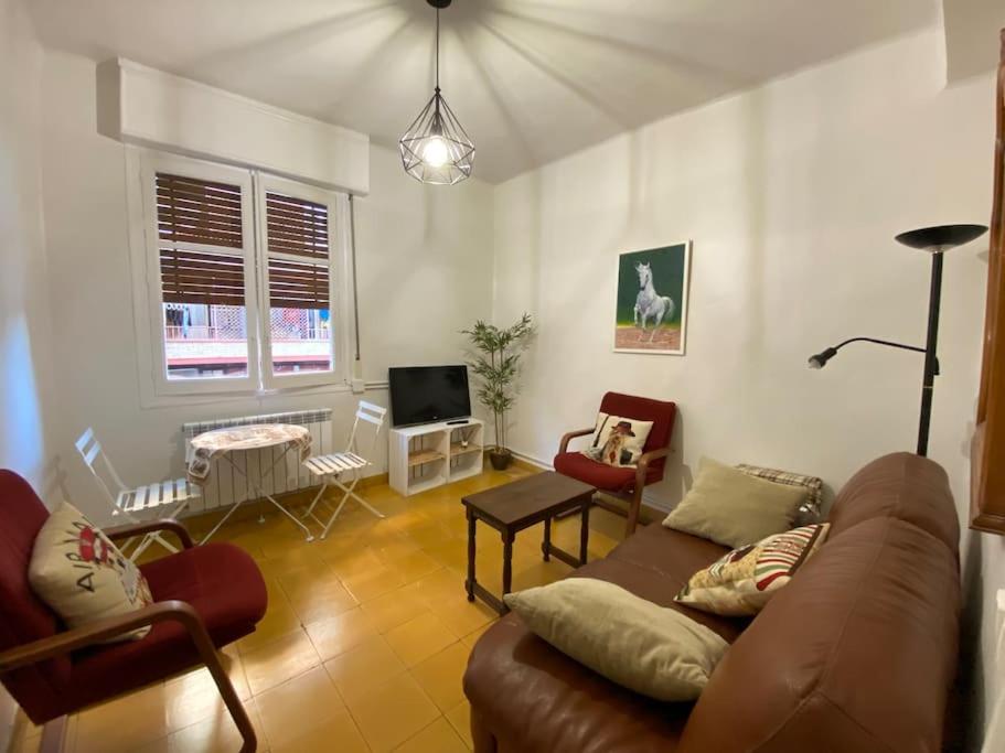 a living room with a couch and chairs and a tv at Six wine lovers in Logroño in Logroño