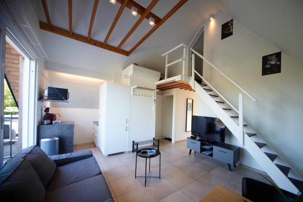 a living room with a couch and a staircase at Apartment with a view and parking in Brecht