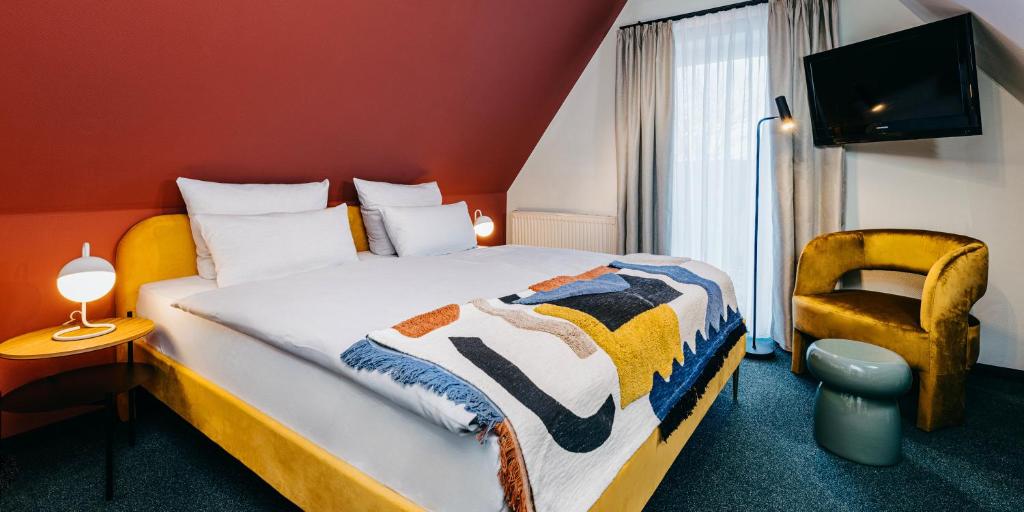 ein Hotelzimmer mit einem Bett und einem Stuhl in der Unterkunft Boutique-Hotel Zur alten Post - Stammhaus in Büsum