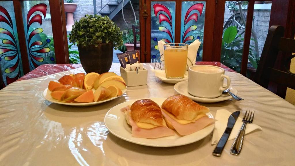 a table with two plates of food and cups of coffee at Hotel Rivera in Colonia del Sacramento