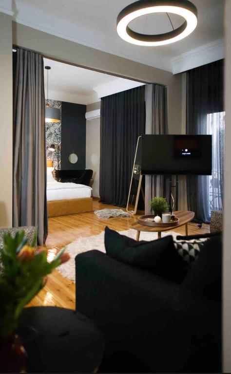 a living room with a couch and a flat screen tv at 4 TRAVELERS Together in Thessaloniki