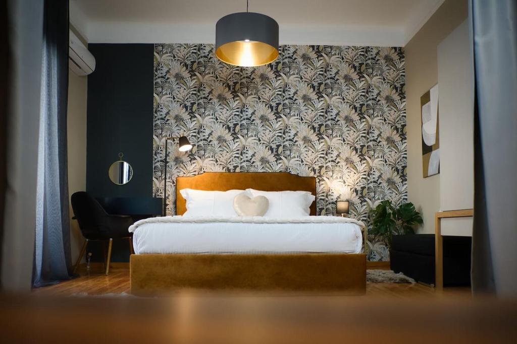 a bedroom with a bed and a wall with a wallpaper at 4 TRAVELERS Together in Thessaloniki