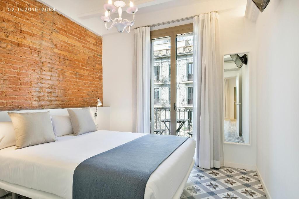 Postel nebo postele na pokoji v ubytování Uma Suites Sagrada Familia