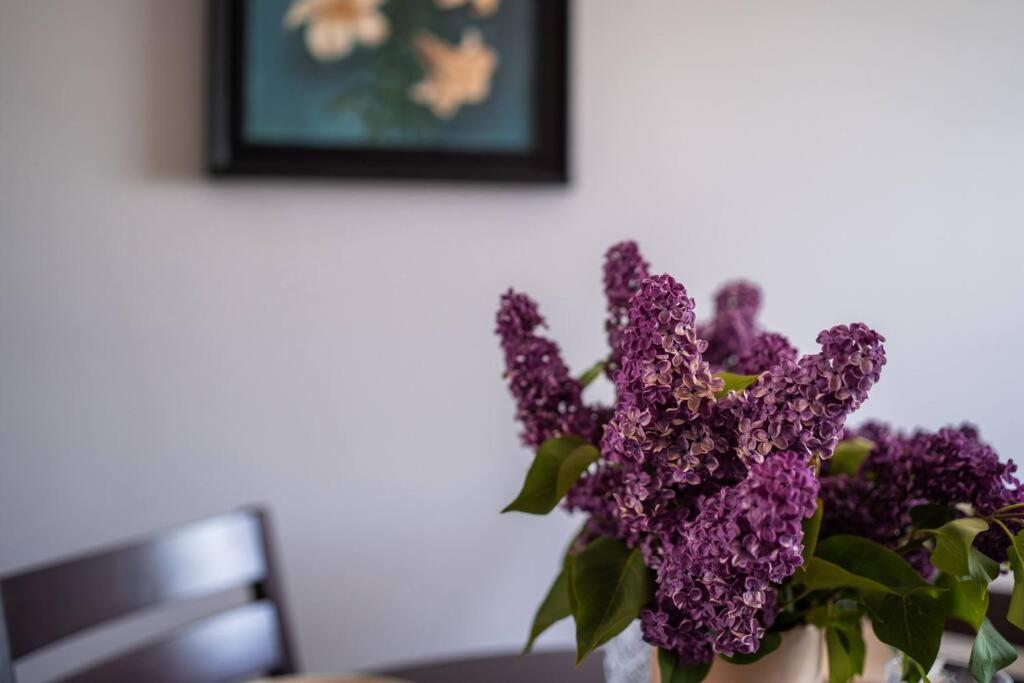 a vase filled with purple flowers on a table at Cozy apartment in the city center of Kärdla in Kärdla
