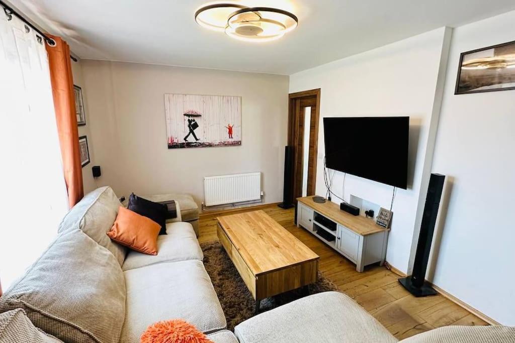 a living room with a couch and a flat screen tv at Stunning 3 bed house sleeps6 in Nottingham