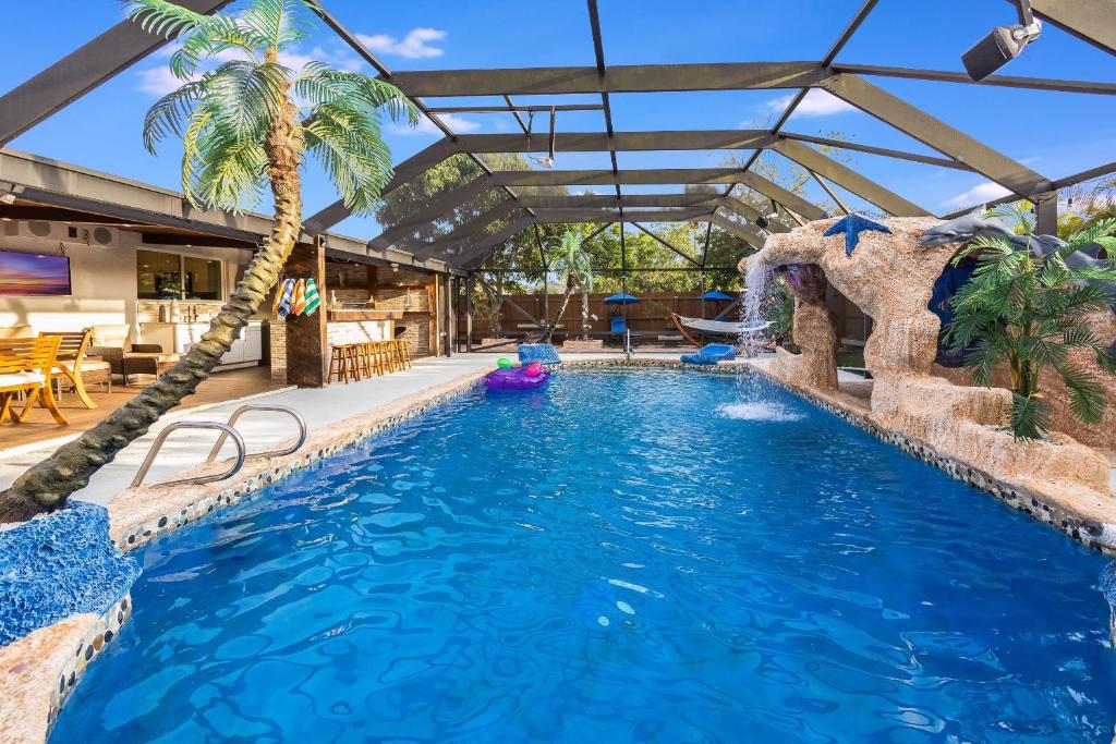 een zwembad met een palmboom in een resort bij Fantasy Resort OMG PoolWaterfall outdoorKitchn Gym in Lake Worth