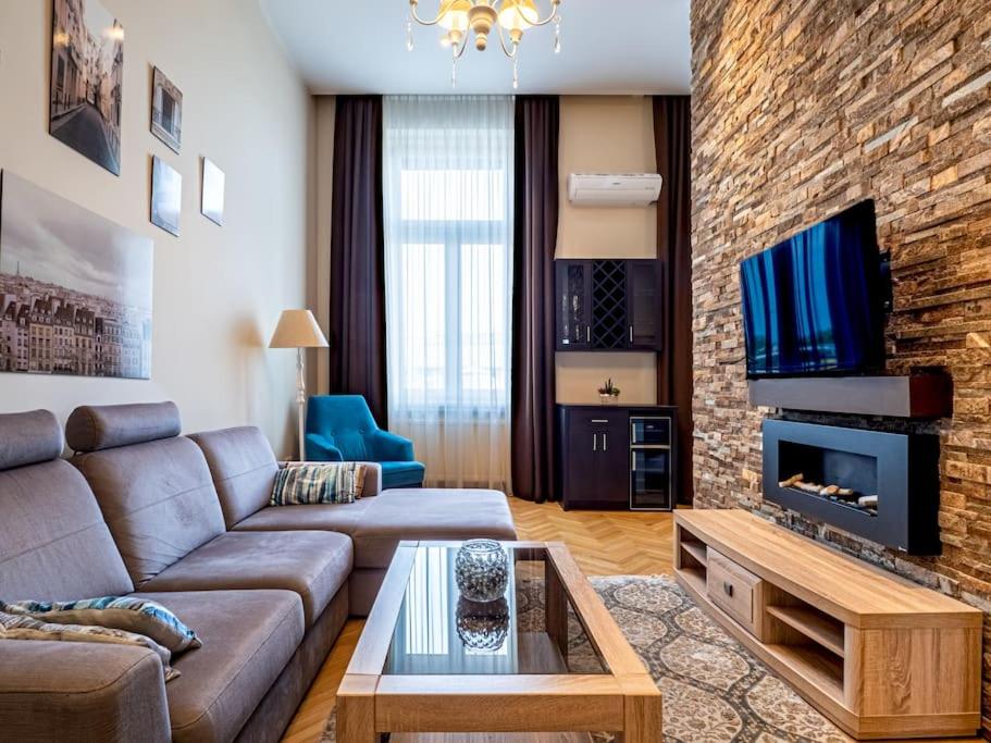 布達佩斯的住宿－Westend Apartment，带沙发和砖墙的客厅