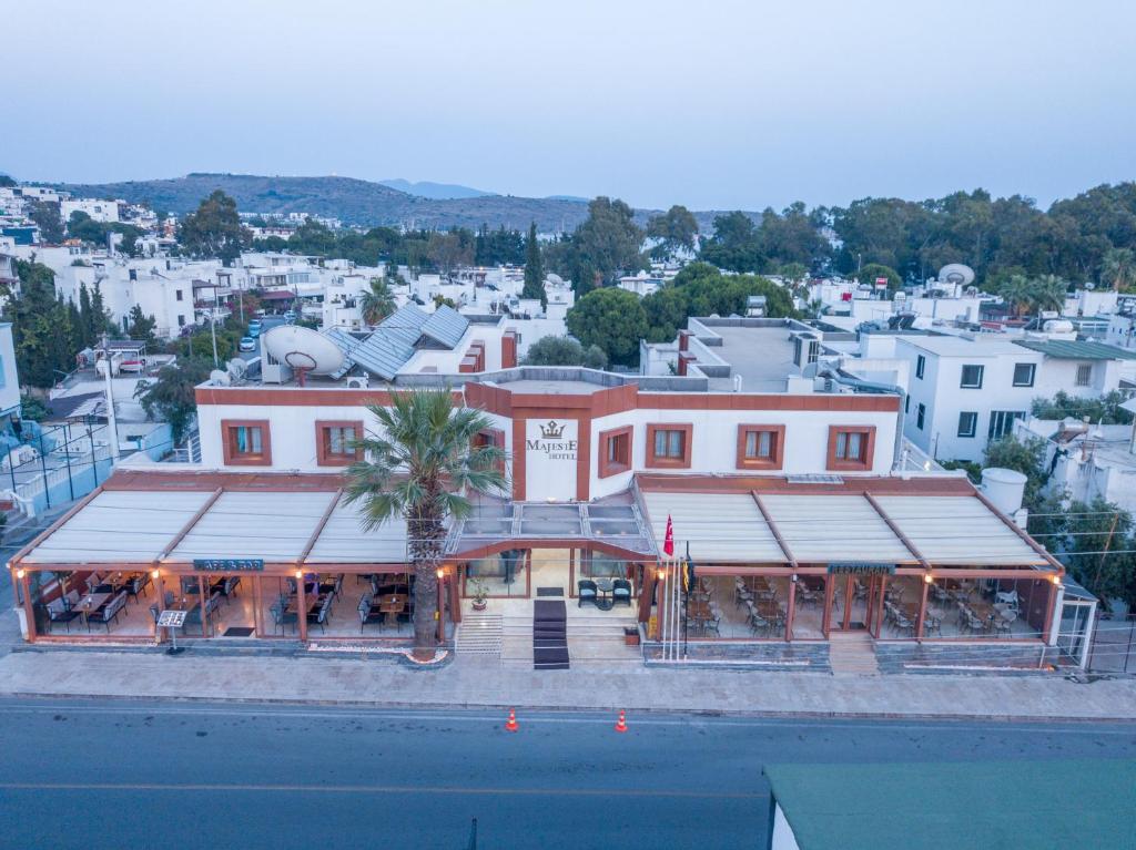 a large red building with a restaurant in front of a city at Majeste Hotel Bodrum in Bodrum City