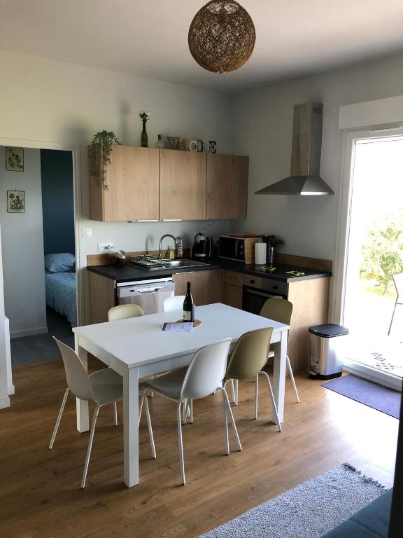 - une cuisine avec une table et des chaises blanches dans la chambre dans l'établissement Petit Gîte de Javernières Rez de jardin, à Villié-Morgon