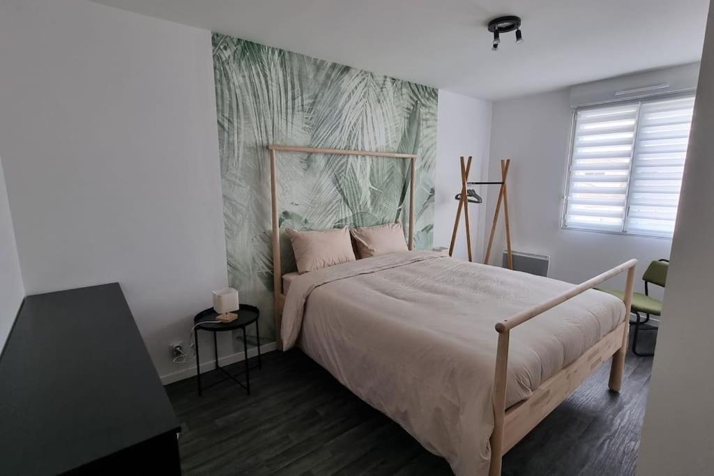 1 dormitorio con 1 cama grande y cabecero de madera en Entre terre et mer en Saint-Brevin-les-Pins