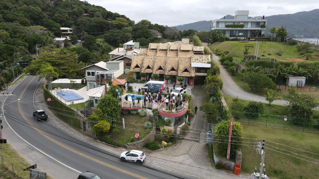 a house on a hill next to a road at Pousada Bangalôs Da Mole - Florianópolis in Florianópolis