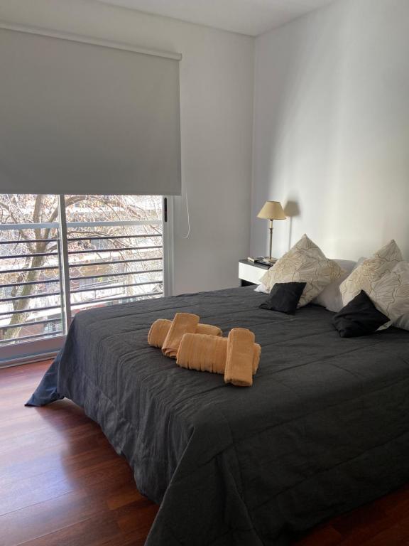 ブエノスアイレスにあるDepartamento en Caballito con Sauna y Pileta,en Caballitoのベッドルーム1室(大型ベッド1台、タオル2枚付)
