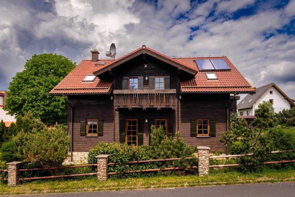 uma casa de madeira com um telhado vermelho em Luxusní horská chata Boží Dar em Boží Dar